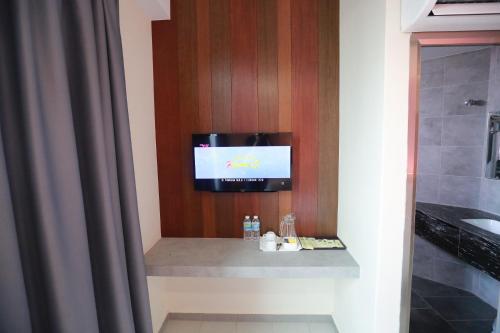 a tv hanging on a wall in a bathroom at Pantai Regal Hotel in Kuantan