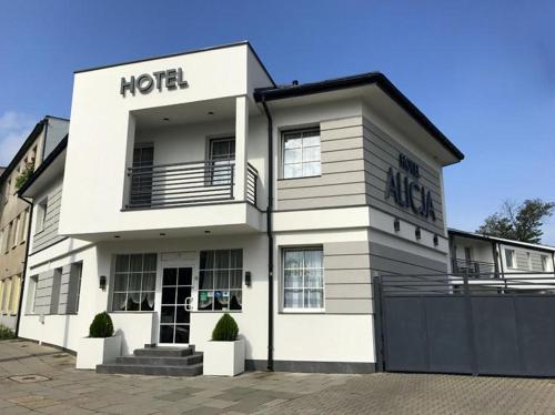 a white building with a hotel sign on it at Hotel Alicja in Łódź