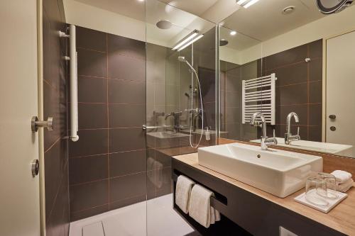 a bathroom with a sink and a shower at HYPERION Hotel Hamburg in Hamburg
