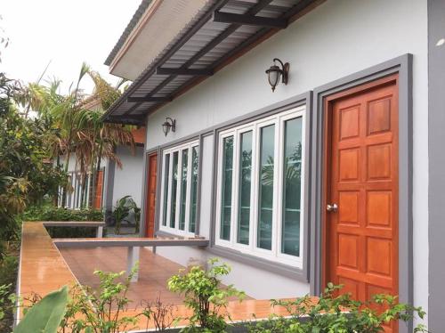 a house with a red door and a patio at Lamphurai Riverside Resort and Spa in Trat