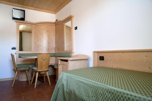 a bedroom with a bed and a desk and a mirror at Agritur Scoiattolo in Coredo