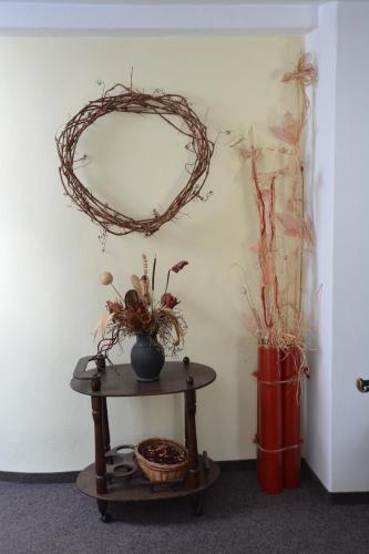 a room with a wreath on the wall and a table at Penzion na Zborově in Strakonice