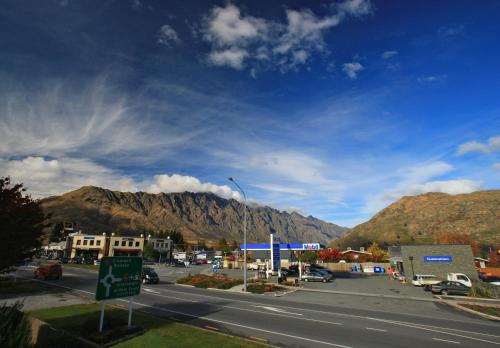 a street in a town with mountains in the background at Queenstown Gateway Apartments in Queenstown