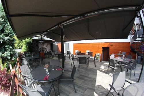 a patio with tables and chairs under an umbrella at Apart Hotel Jablonec in Jablonec nad Nisou