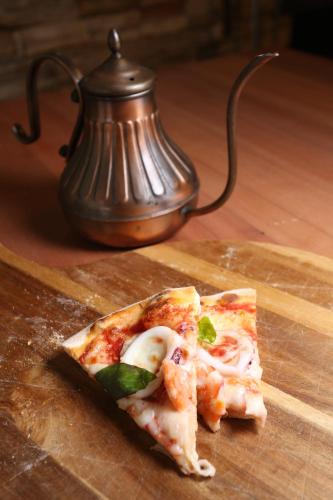 a slice of pizza sitting on top of a wooden table at Black Chimney in Datong