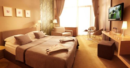a hotel room with a large bed and a chair at Špik Alpine Resort in Kranjska Gora