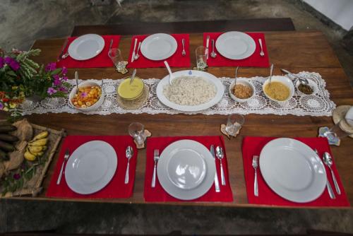 a table with white plates and bowls of food at Moon Isle Beach Bungalow in Nilaveli