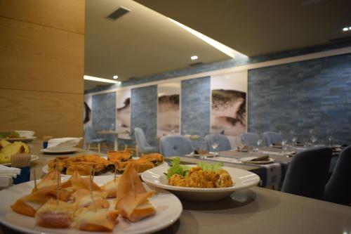 a plate of food on a table in a restaurant at Hotel VIDA Mar de Laxe in Laxe