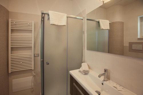 a bathroom with a sink, toilet, and shower stall at Avantgarde Hotel in Conversano