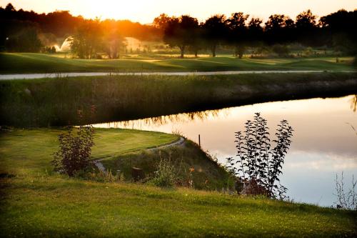 a reflection of a golf course in the water at Pałac Brzeźno Spa & Golf in Oborniki Śląskie