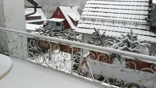 a balcony covered in snow with snow covered roofs at Ferienwohnung Adelsberg in Alpirsbach