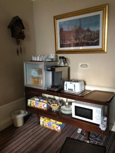 a kitchen with a coffee maker and a microwave on a table at Crown Guest House in Aberdeen