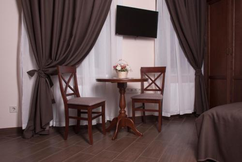 a room with a table and two chairs and a television at Ekaterinoslav in Dnipro