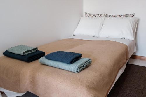 a bed with two towels sitting on top of it at apartment with balcony in the square in Porto