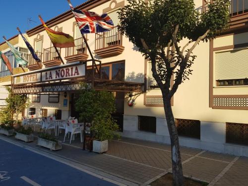 a building with a restaurant with a flag on it at Hotel La Noria in Lepe