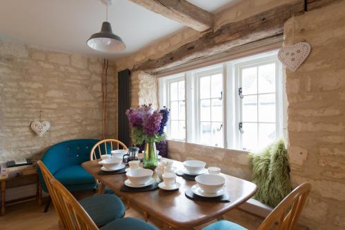 a dining room with a wooden table and blue chairs at Upper Flat, The Manse, Painswick in Painswick