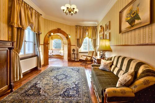 a living room with a couch and a rug at Pałac Brzeźno Spa & Golf in Oborniki Śląskie