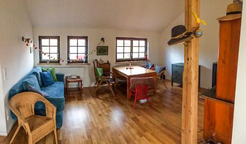 ein Wohnzimmer mit einem blauen Sofa und einem Tisch in der Unterkunft Appartement Alte Schmiede in Lübbenow