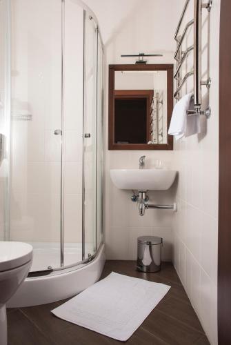 a white bathroom with a sink and a shower at Ekaterinoslav in Dnipro