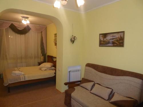 a living room with a couch and a bed at Мини-отель "Ольга" in Truskavets