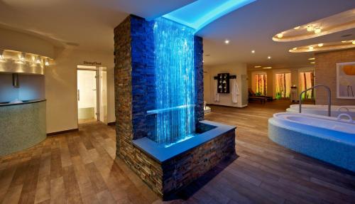 a bathroom with a large bathtub with blue glass at Hotel Kaiserhof in Münster