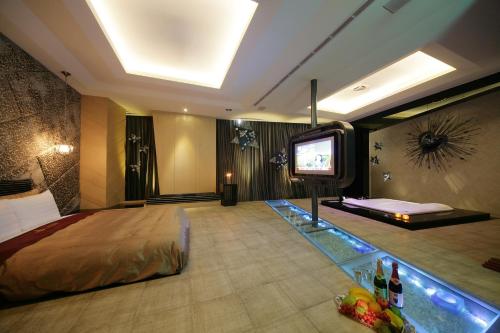 a hotel room with a bed and a flat screen tv at Dubai Villa Motel in Daya
