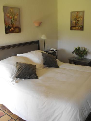 a large white bed with two pillows on it at L'Orée des Chênes, The Originals Relais in La Ferté-Saint-Aubin