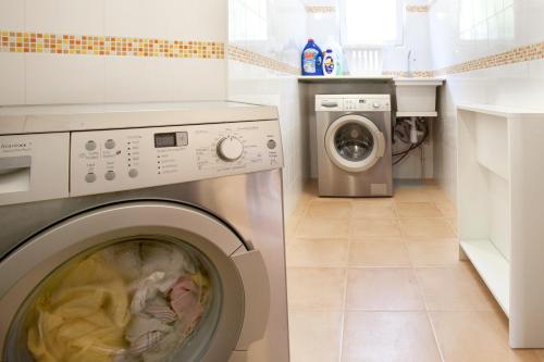 a washer and dryer in a white laundry room at Hotel Rosa in Denia