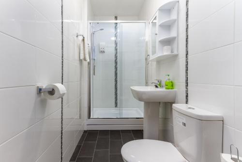 a bathroom with a shower and a toilet and a sink at Maples Hotel in Blackpool