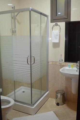 une salle de bains avec douche, toilettes et lavabo dans l'établissement Larissa Suites, à Khobar