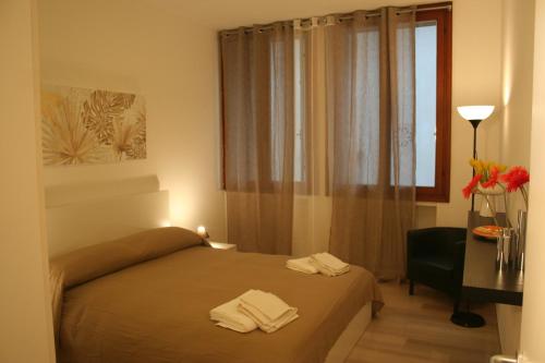 a bedroom with a bed and a desk and a window at Casa Palladio in Vicenza