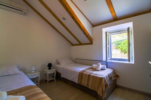a bedroom with two beds and a window at Bargujac Summer House in Vis