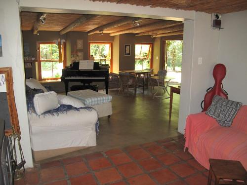 a living room with couches and a grand piano at High Hopes in Greyton