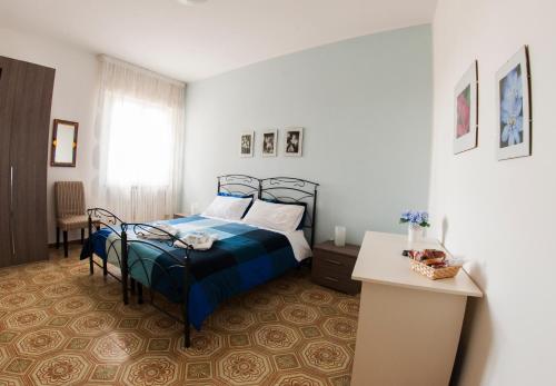 a bedroom with a bed with a blue comforter at B&B da LEO in Carovigno