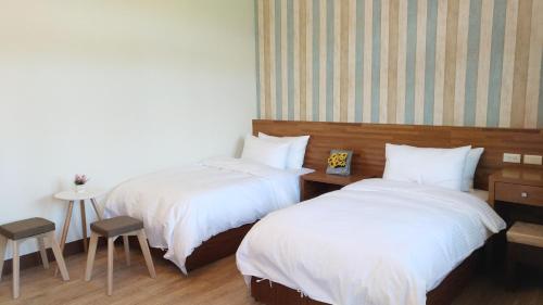 a hotel room with two beds and a table and chairs at Shui Bu Zi Farmhouse in Puli
