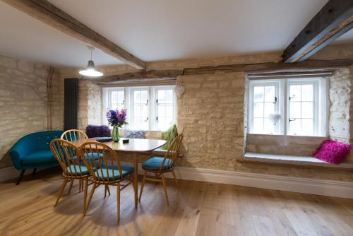 a dining room with a table and chairs and a window at Upper Flat, The Manse, Painswick in Painswick