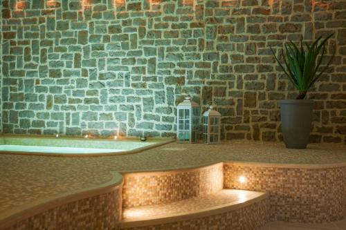 um quarto com uma banheira e uma parede de tijolos em Ripa Relais Colle Del Sole em Torchiagina