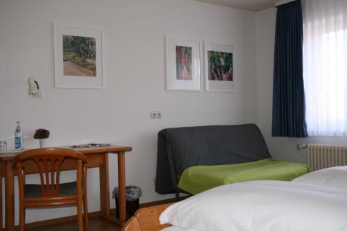 a bedroom with a desk and a bed and a chair at Sontheimer Wirtshäusle in Sontheim im Stubental