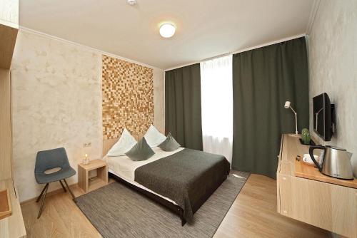 a hotel room with a bed and a tv at De`Lore Park Hotel Domodedovo in Domodedovo