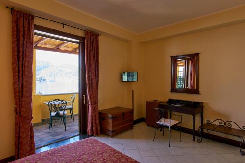 Hotel A Pinnata في ليباري: غرفة نوم بسرير ومكتب ونافذة