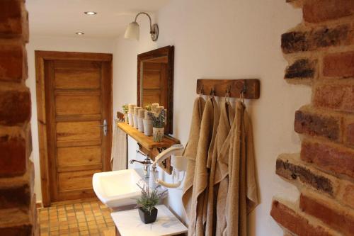 ein Bad mit einem Waschbecken und Handtüchern an der Wand in der Unterkunft Haus62 in Weißwasser