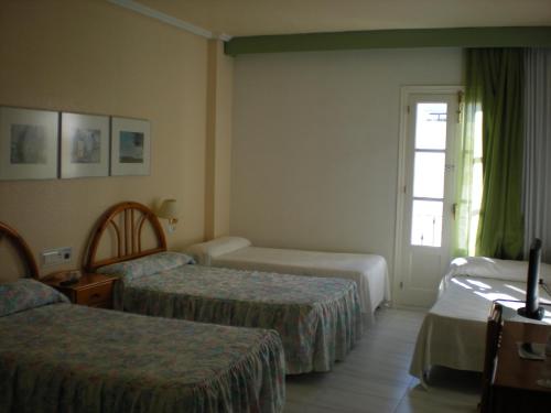 a hotel room with two beds and a window at Hotel Terraza Carmona in Vera