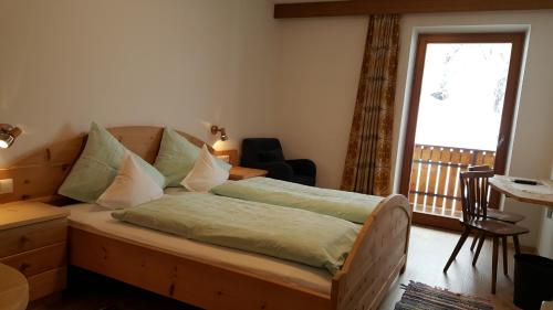 a bedroom with a bed and a desk and a window at Hotel Pension Moarhof in Vallarga