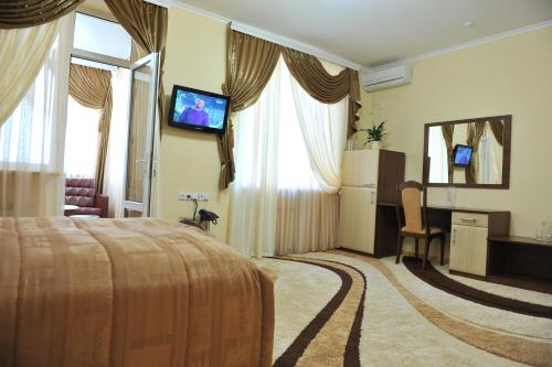 a hotel room with a bed and a flat screen tv at Andinna Hotel in Chernivtsi