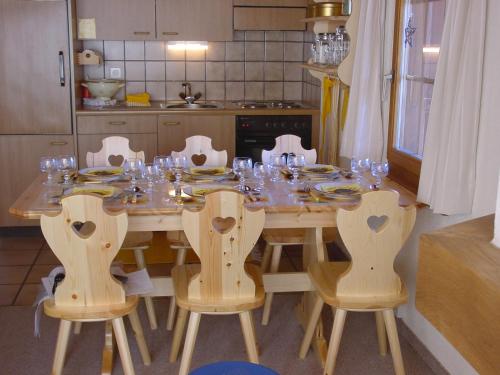 a kitchen with a table and chairs with glasses on it at bel-air 21 u.23 in Bellwald