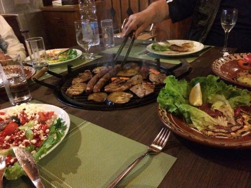 a table with plates of food and a plate of food at Hotel Bozhentsi in Chernevtsi