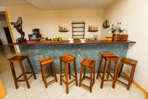 a bar with four wooden stools in a kitchen at Hotel Vanivola & SPA in Sainte Marie