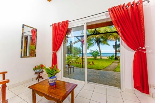 a living room with a table and a large window at Hotel Vanivola & SPA in Sainte Marie