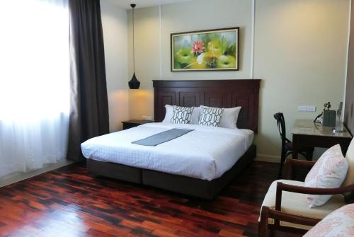 ein Schlafzimmer mit einem Bett, einem Tisch und einem Stuhl in der Unterkunft Bloom Boutique Hotel & Cafe in Vientiane