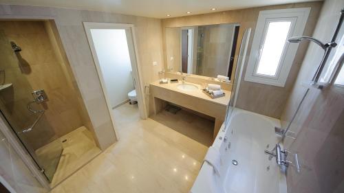 ein Bad mit einer Dusche, einem Waschbecken und einem Spiegel in der Unterkunft Luxury Bay View Villa 28 Right On The Beach in Protaras